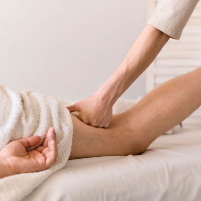 la praticienne exécute une pression sur le haut de la cuisse postérieure pour assouplir les tension du haut de la jambe