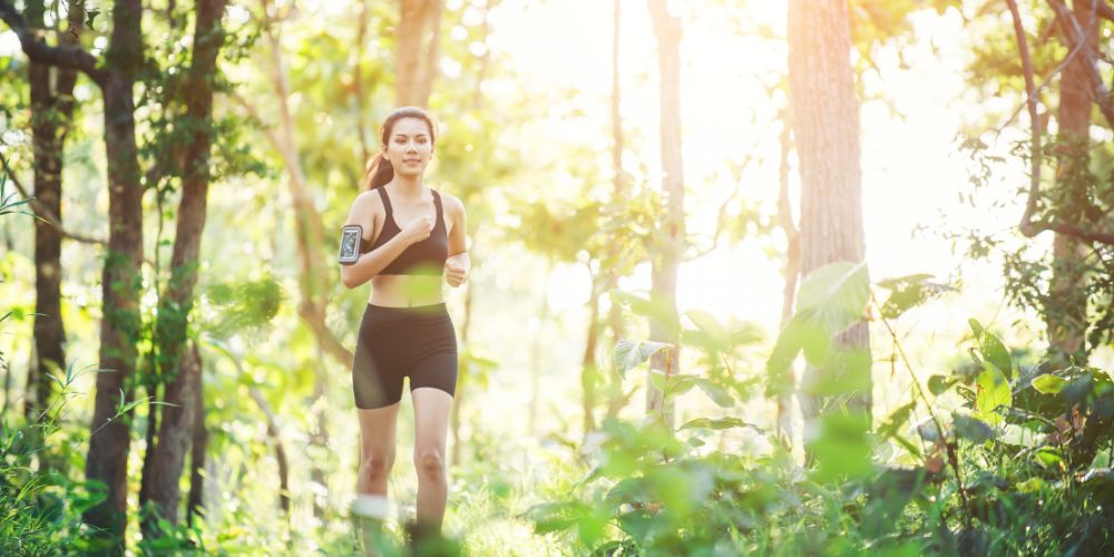 une jeune femme brune court dans la forêt pour se régénérer