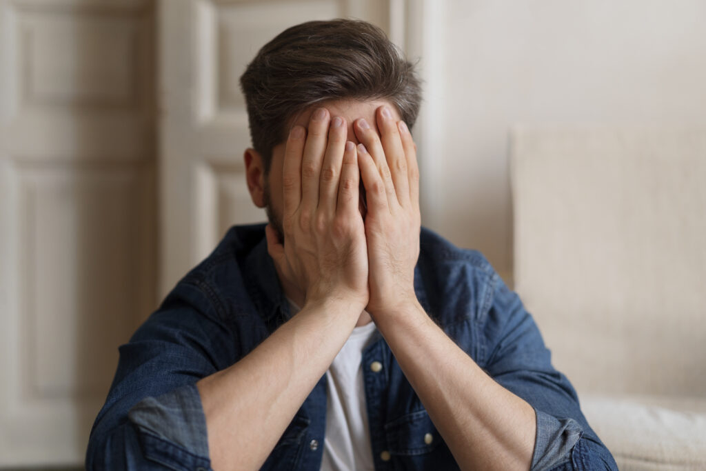 un homme se prends la tête dans les mains et exprime beaucoup de fatigue
