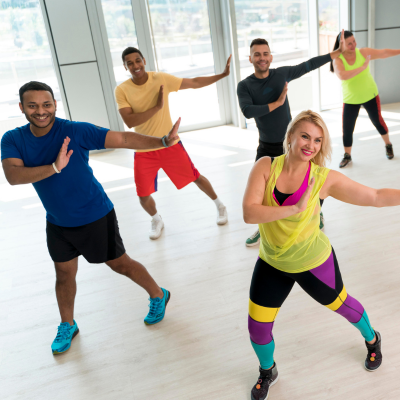Groupe de zumba en salle en train de danser avec le sourire