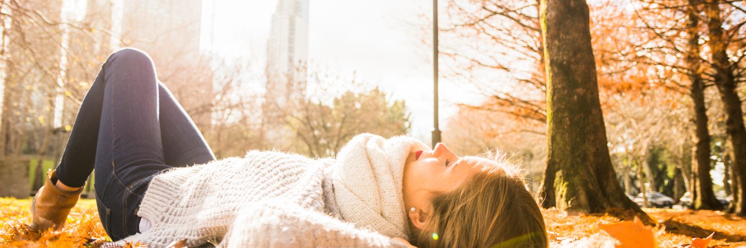 femme allongée paisiblement dans la forêt aux lueurs de l'automne